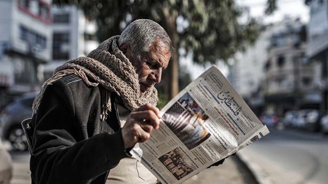 فلسطيني يطالع الصحف في غزة